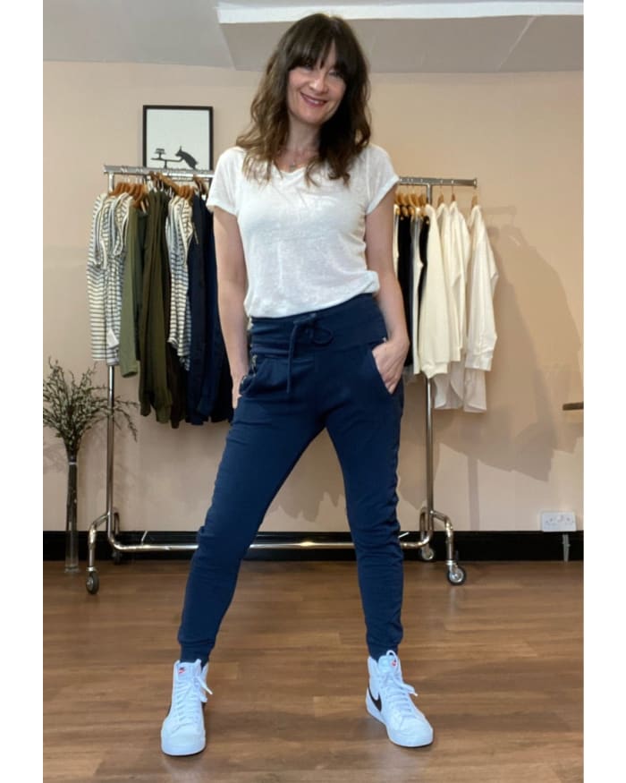 a woman standing in front of a rack of clothes