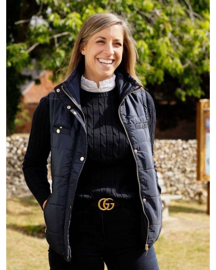 a woman smiling in a black vest