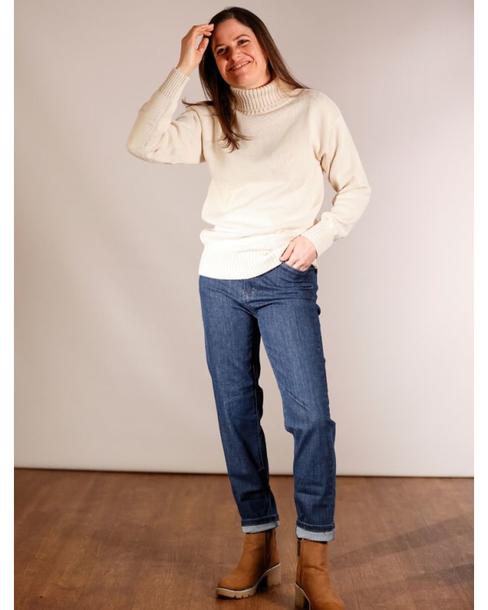 a woman in a white sweater and jeans