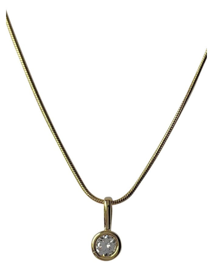 a gold necklace with a round pendant