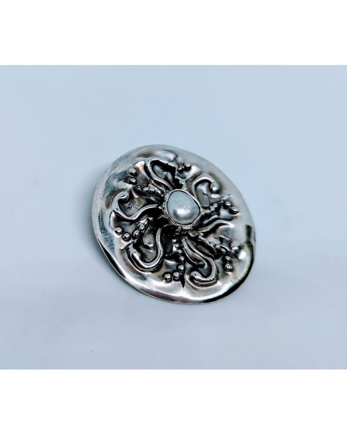 a silver button with a pearl