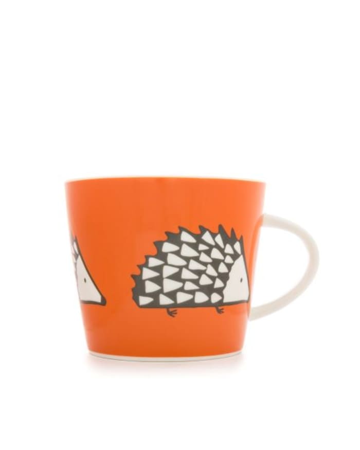 an orange mug with a drawing of hedgehogs