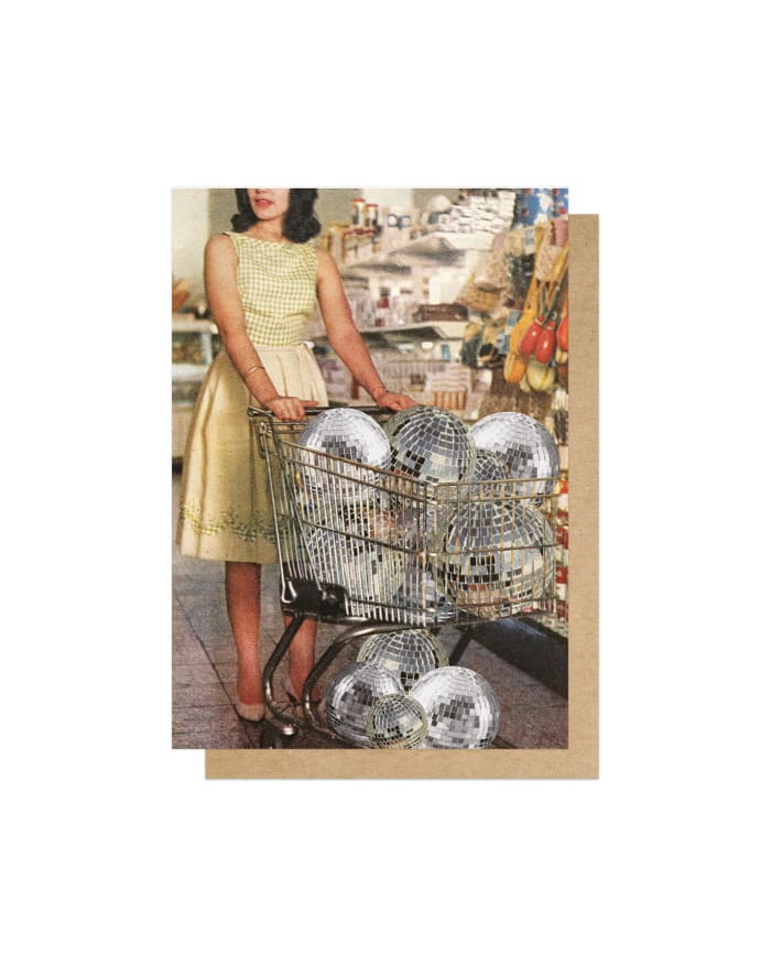 a woman pushing a shopping cart full of disco balls