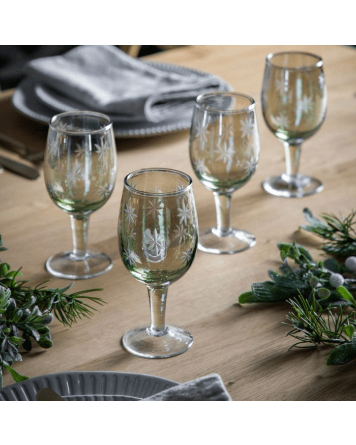 a table with wine glasses and plants