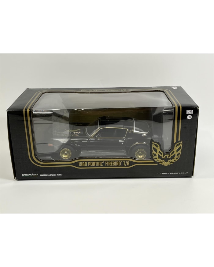 a black and gold toy car in a box