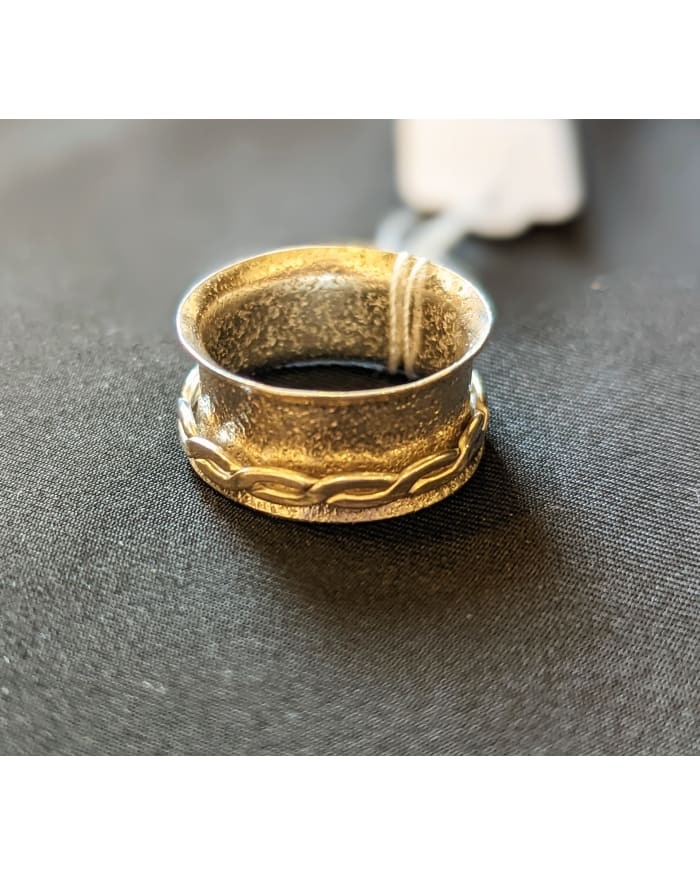 a gold ring with a white cord