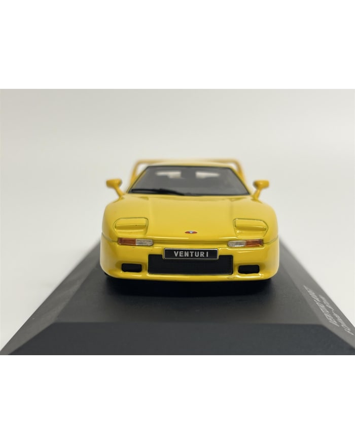 a yellow toy car on a black surface