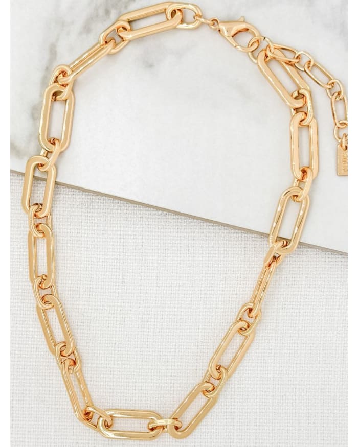 a gold chain on a white surface