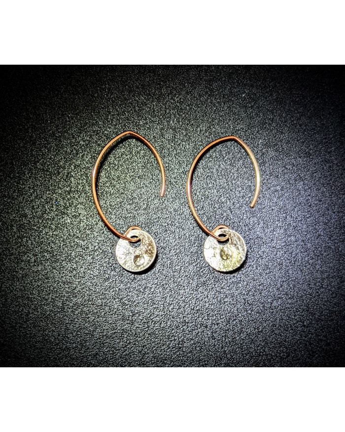 a pair of earrings on a black surface