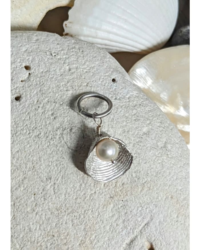 a silver and pearl necklace on a rock