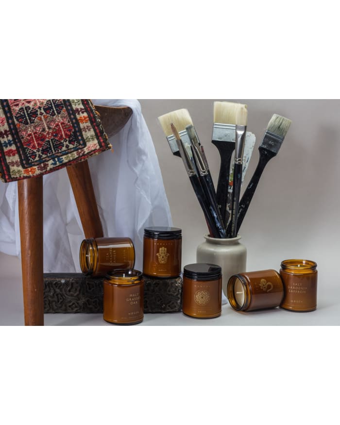 a group of brown jars with paint brushes in a vase