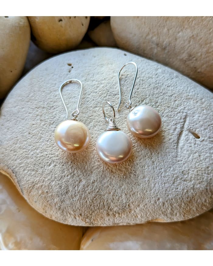 a group of pearl earrings on a rock