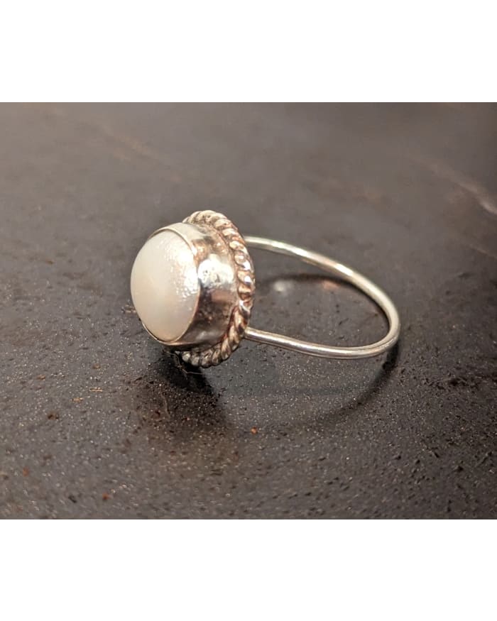 a silver ring with a white stone in the middle