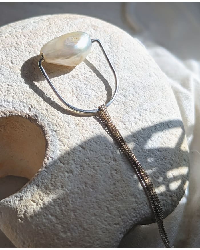 a pearl necklace on a rock