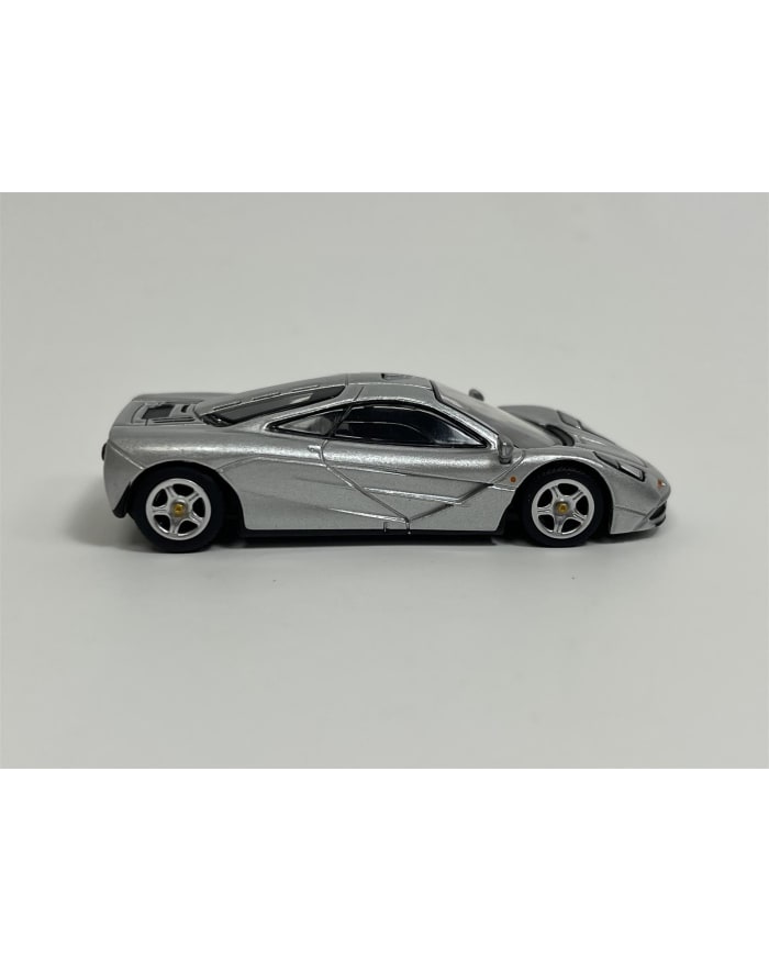 a silver toy car on a white background