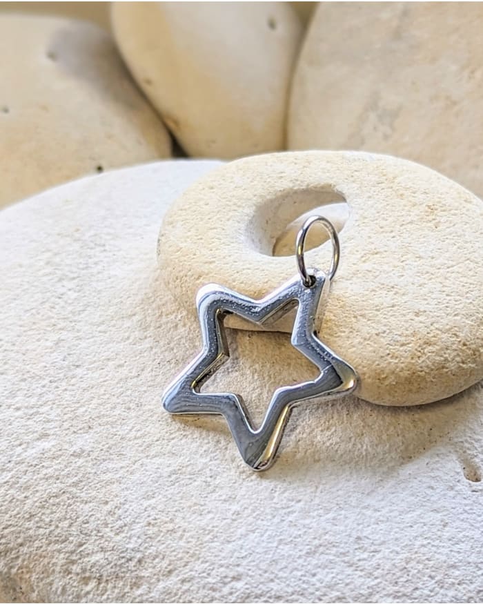 a silver star pendant on a round stone