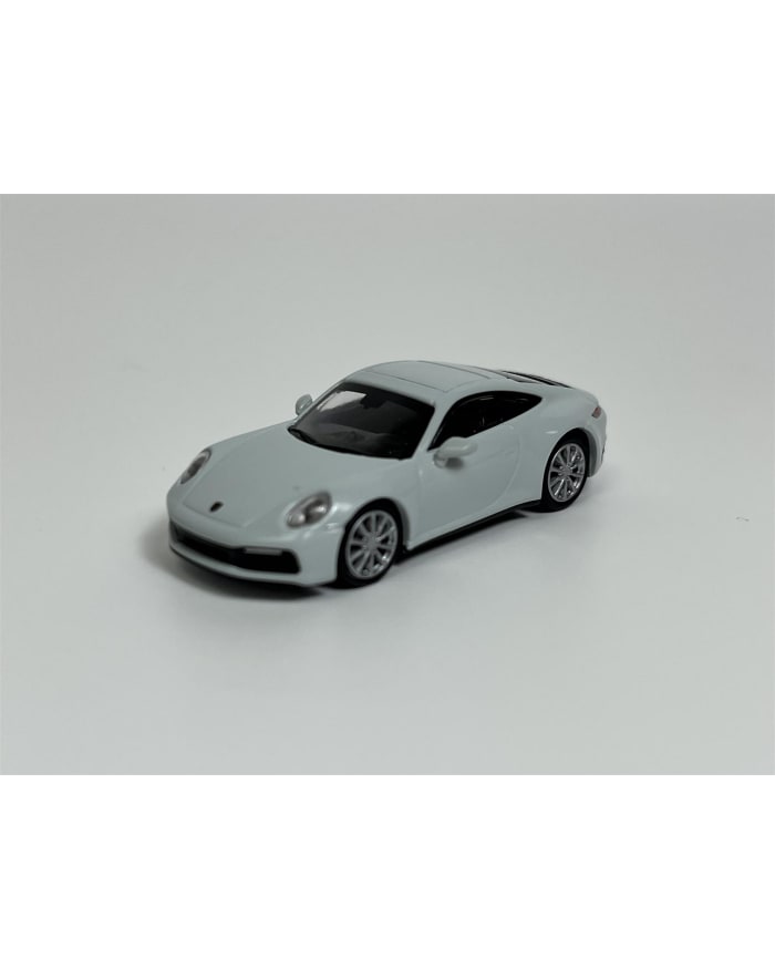 a white toy car on a white surface