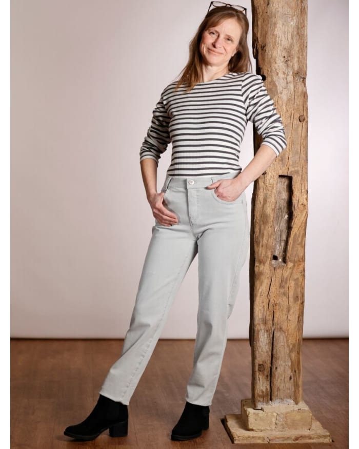 a woman leaning against a wooden post