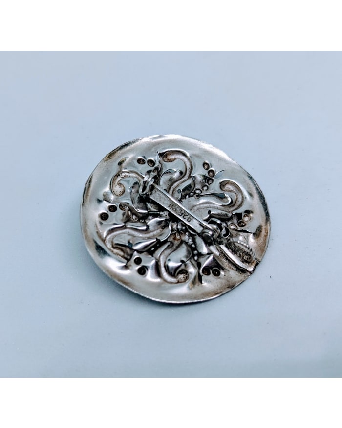 a silver round object with a metal clasp