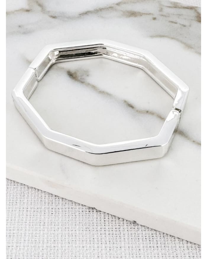 a silver bracelet on a marble surface