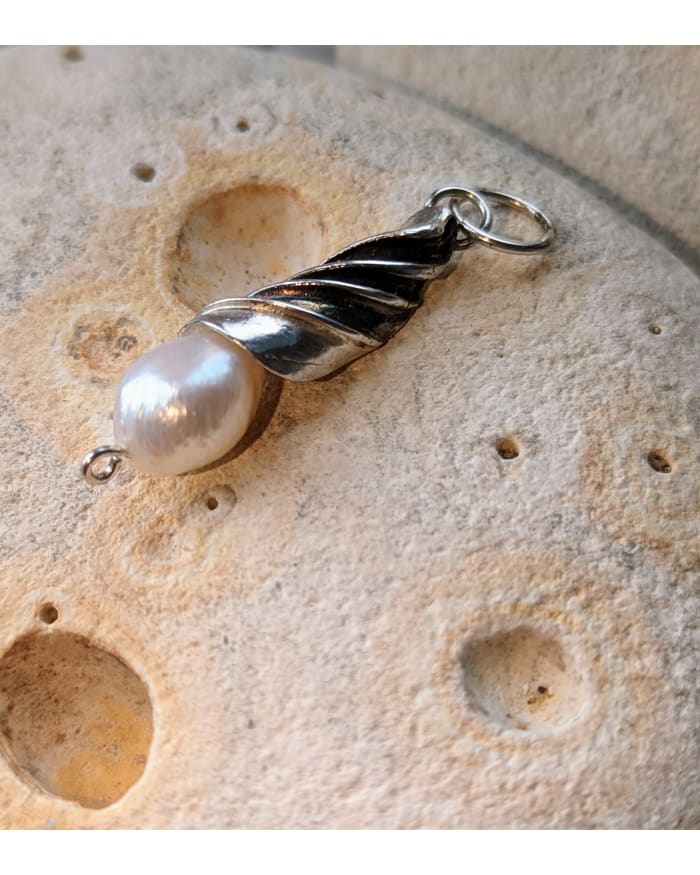 a pearl pendant on a rock