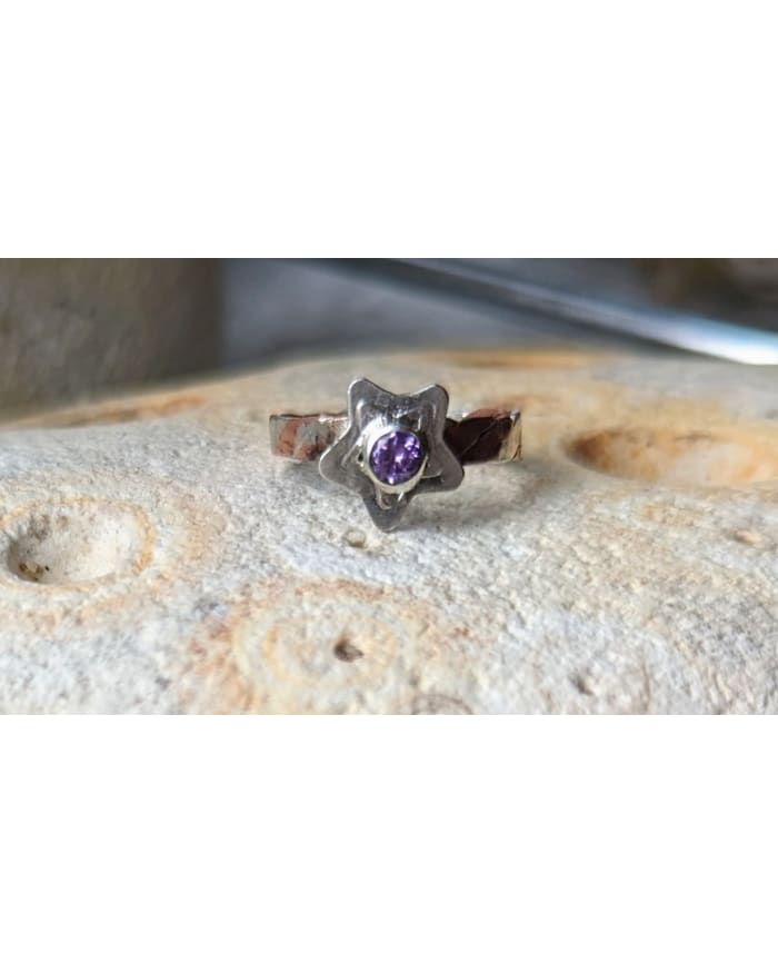 a ring with a purple stone in the middle