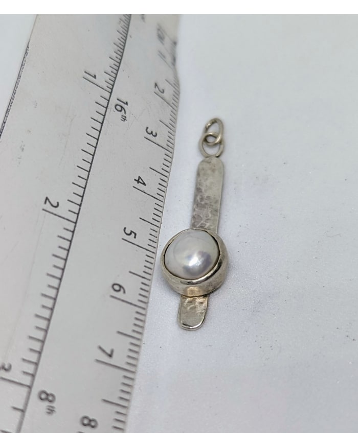 a silver and white necklace with a pearl in the middle