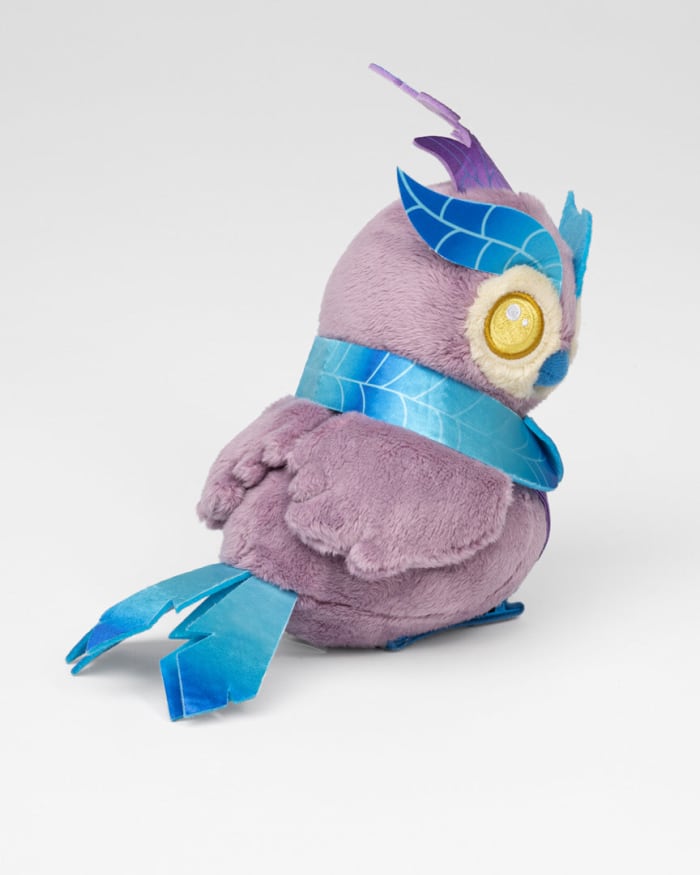 a purple stuffed animal with blue scarf