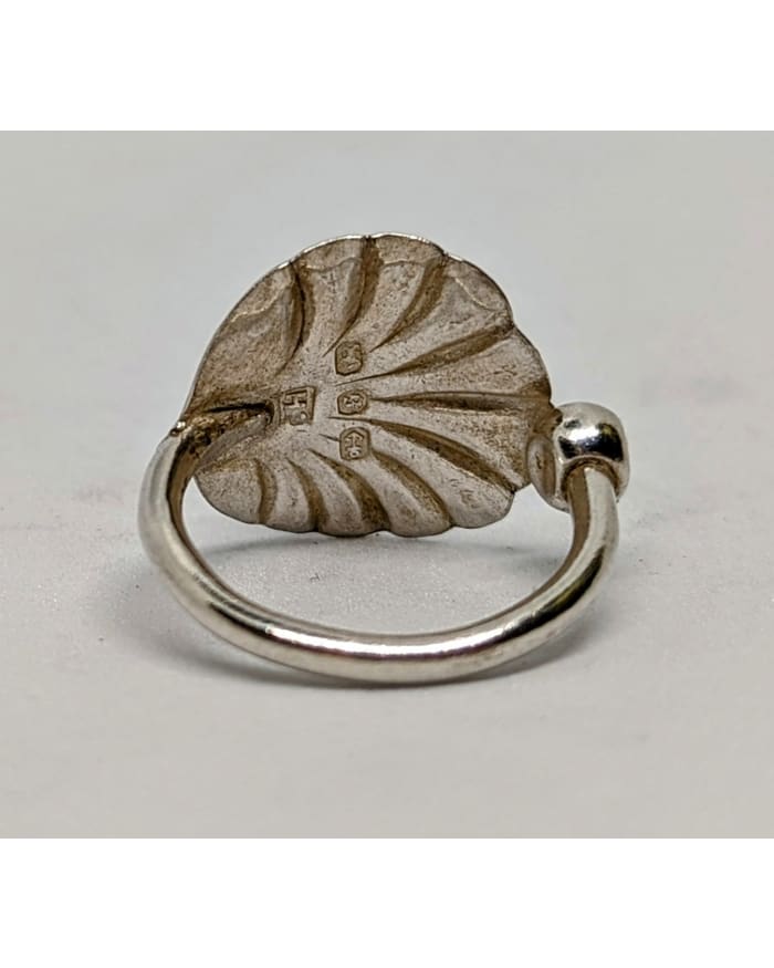 a silver ring with a shell design