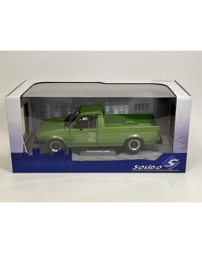 a green toy truck in a clear plastic box