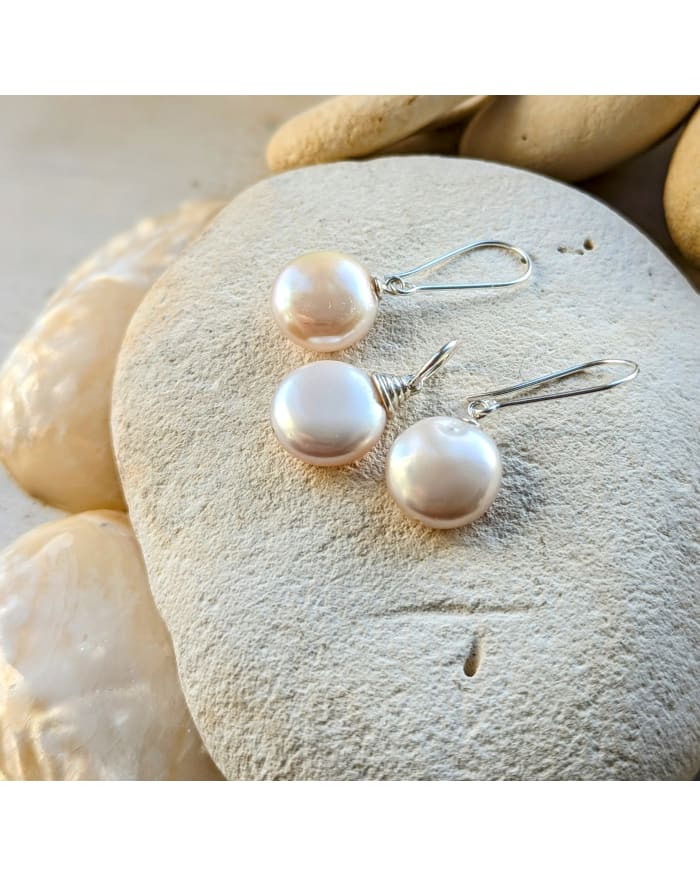 a group of pearl earrings on a rock