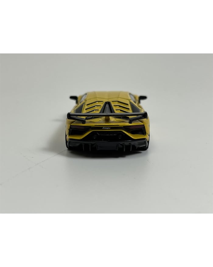 a yellow toy car on a white surface