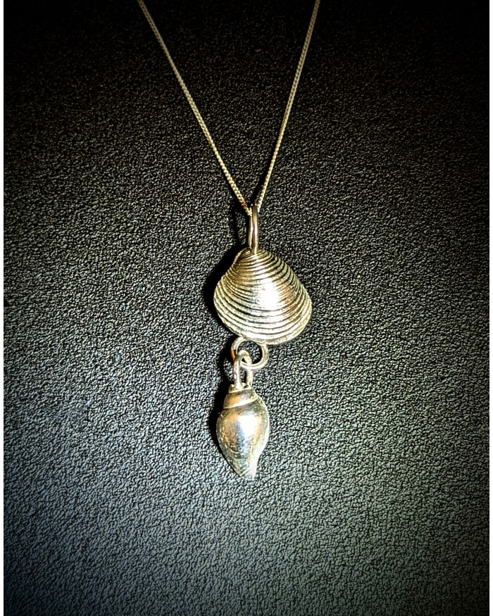 a gold necklace with a shell pendant