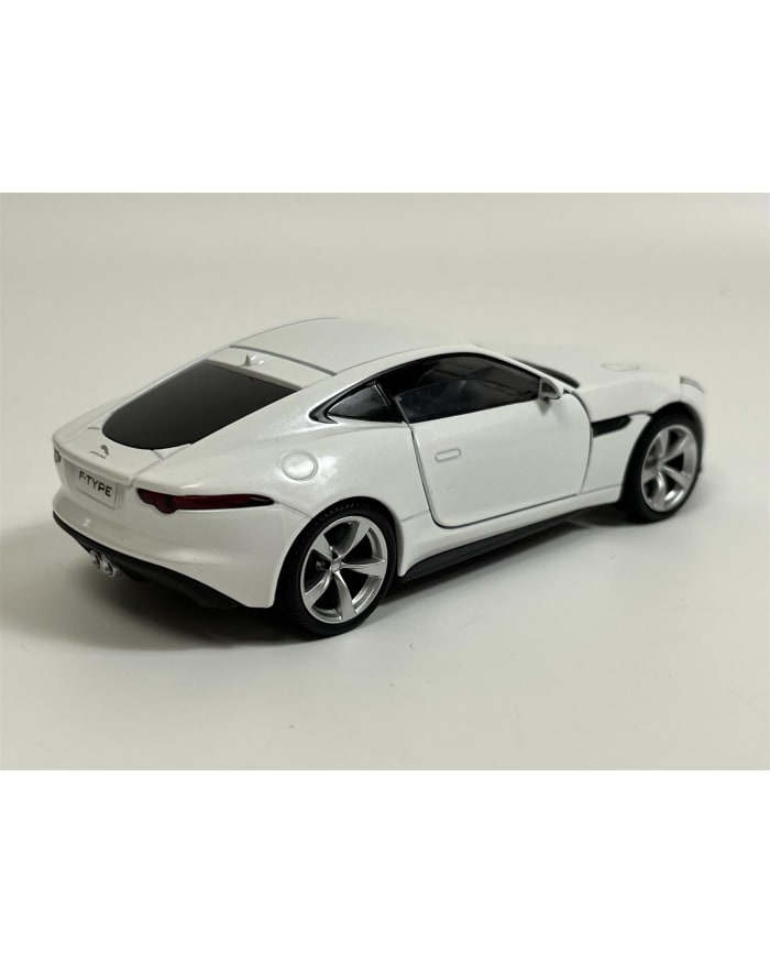 a white toy car on a white surface