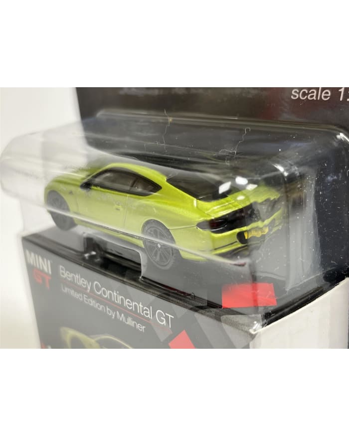 a green toy car in a plastic package