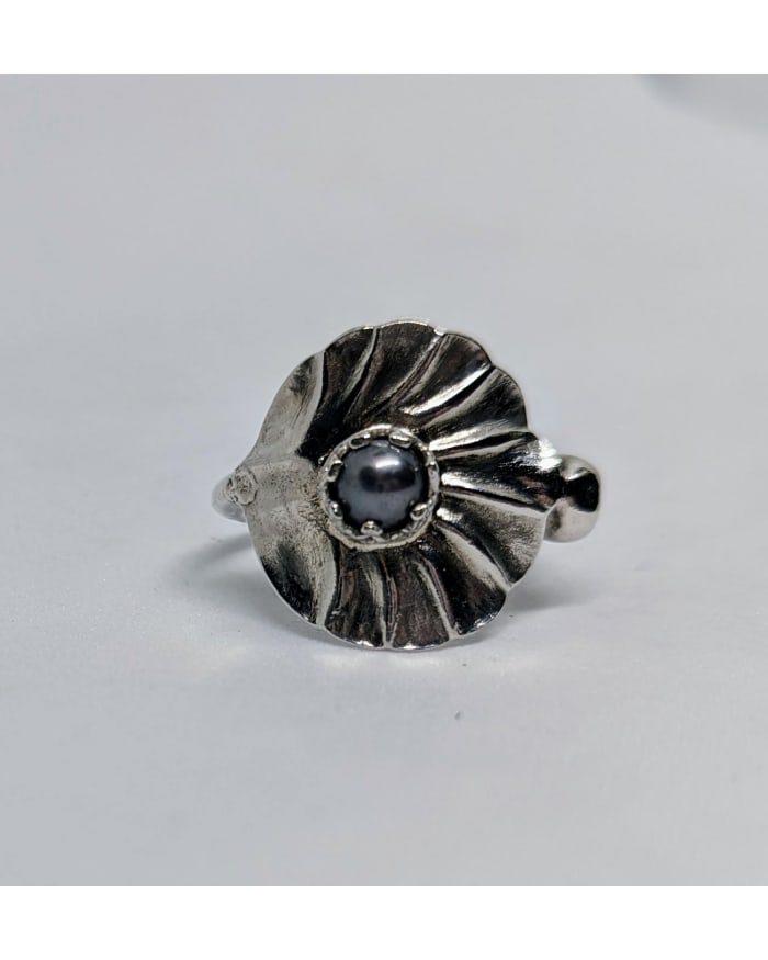 a silver ring with a pearl in the center