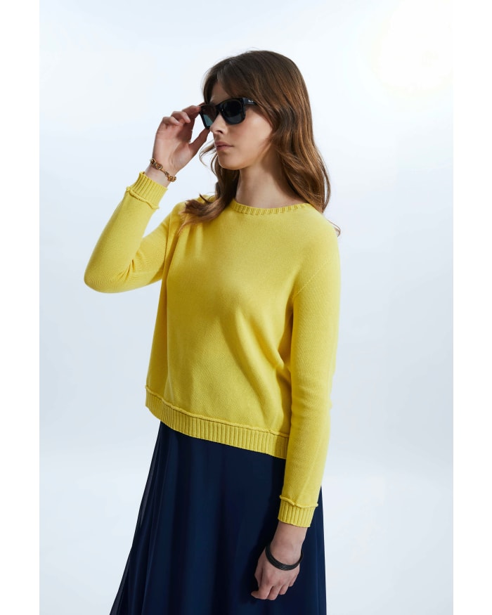 a woman wearing a yellow sweater and sunglasses