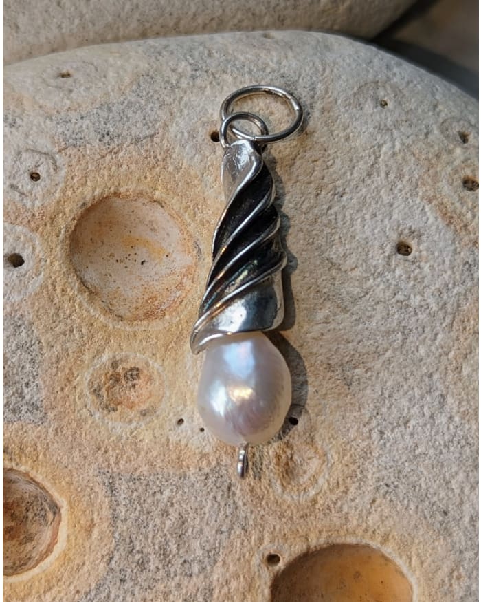 a pearl pendant on a rock