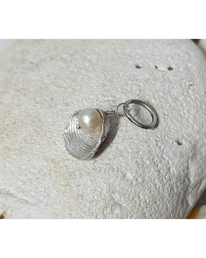 a silver shell with a pearl on it