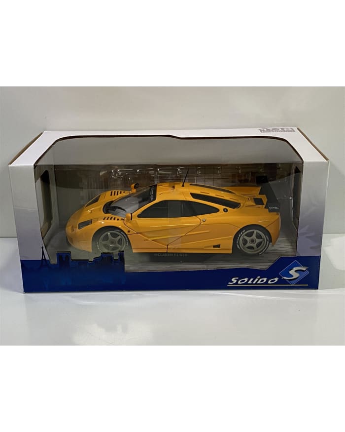 a yellow toy car in a plastic box