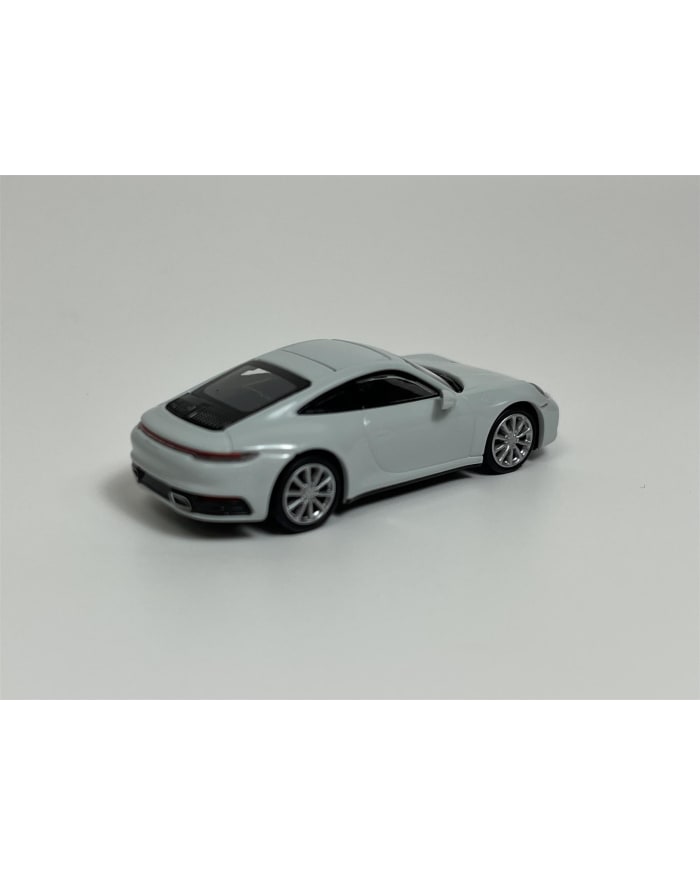 a white toy car on a white surface