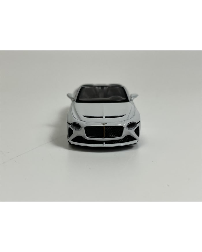 a white toy car on a white surface