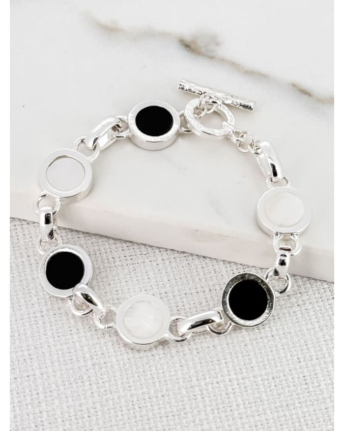 a silver bracelet with black and white circles