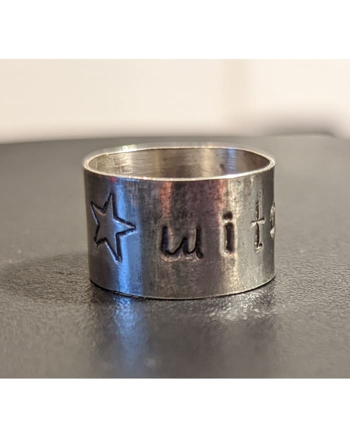a silver ring with a star and a star engraved on it