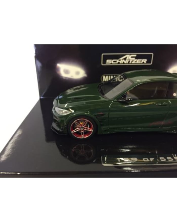 a green toy car in a box