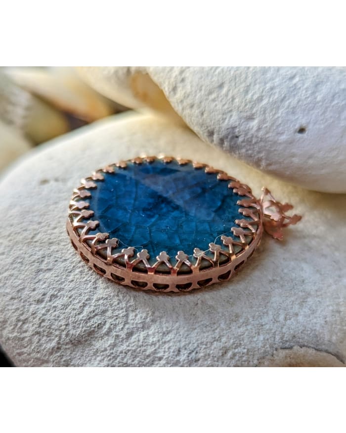 a blue stone with a gold ring on top of it