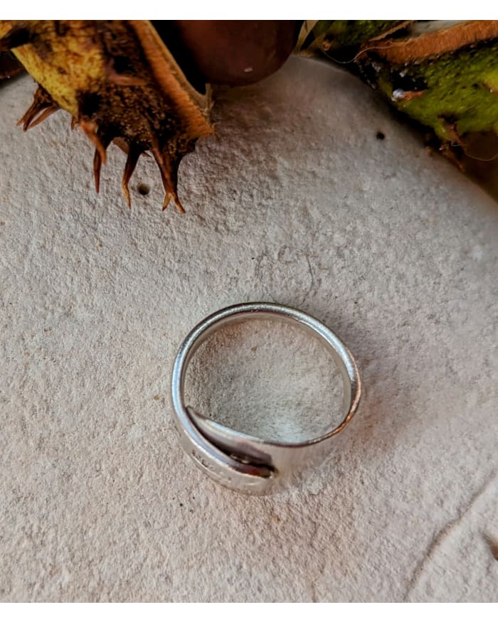 a silver ring on a white surface