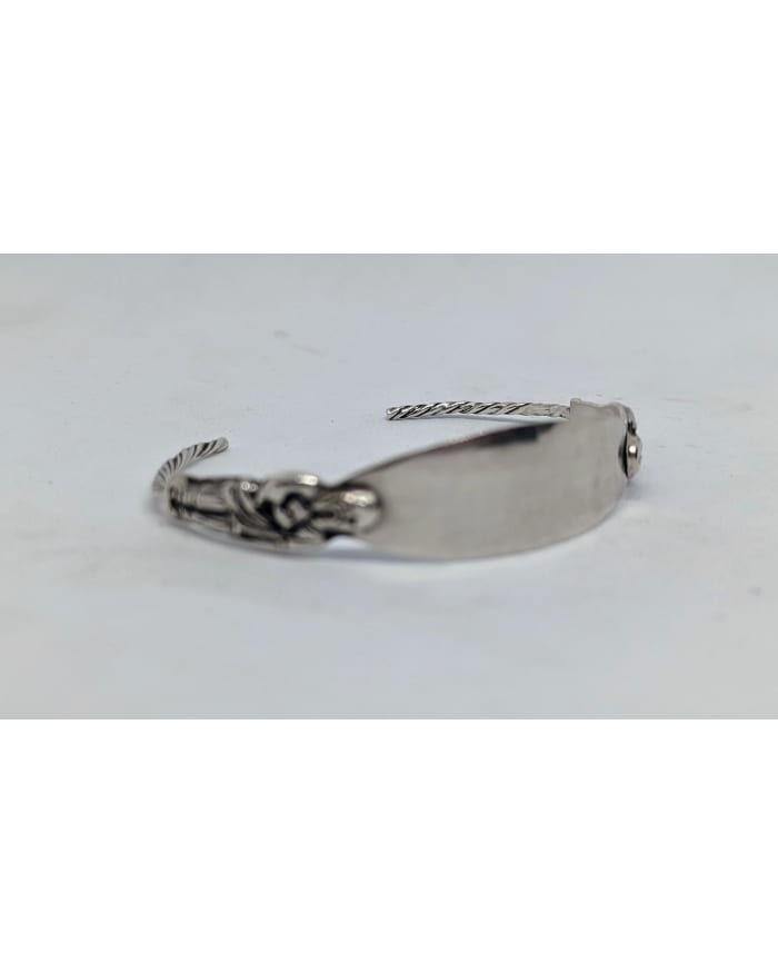 a silver bracelet on a white surface