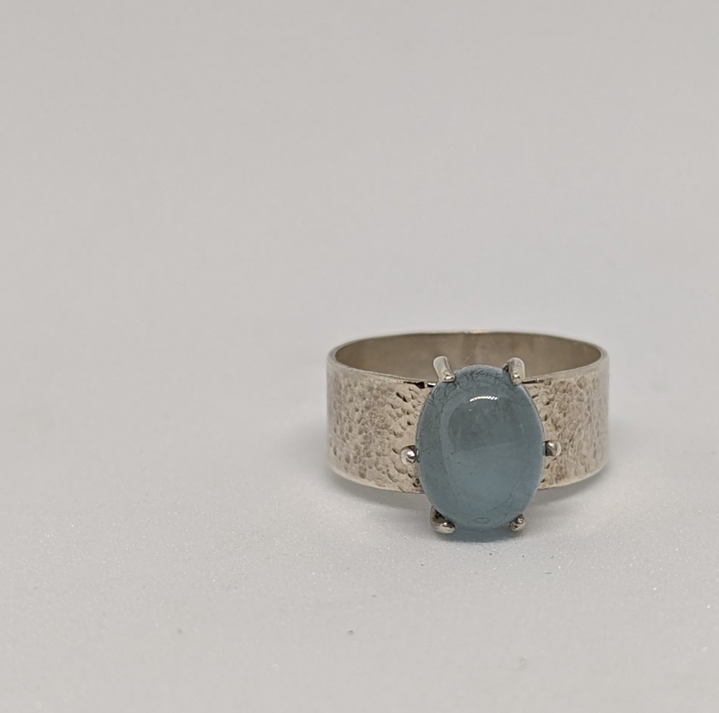 a silver ring with a blue stone