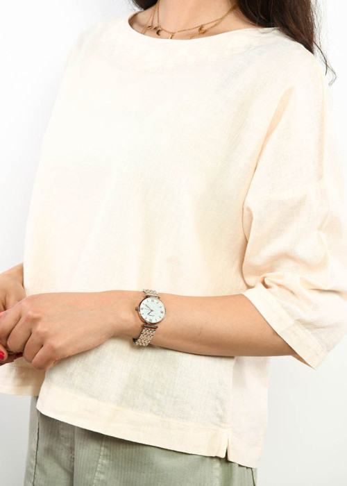 a woman wearing a white shirt and a watch